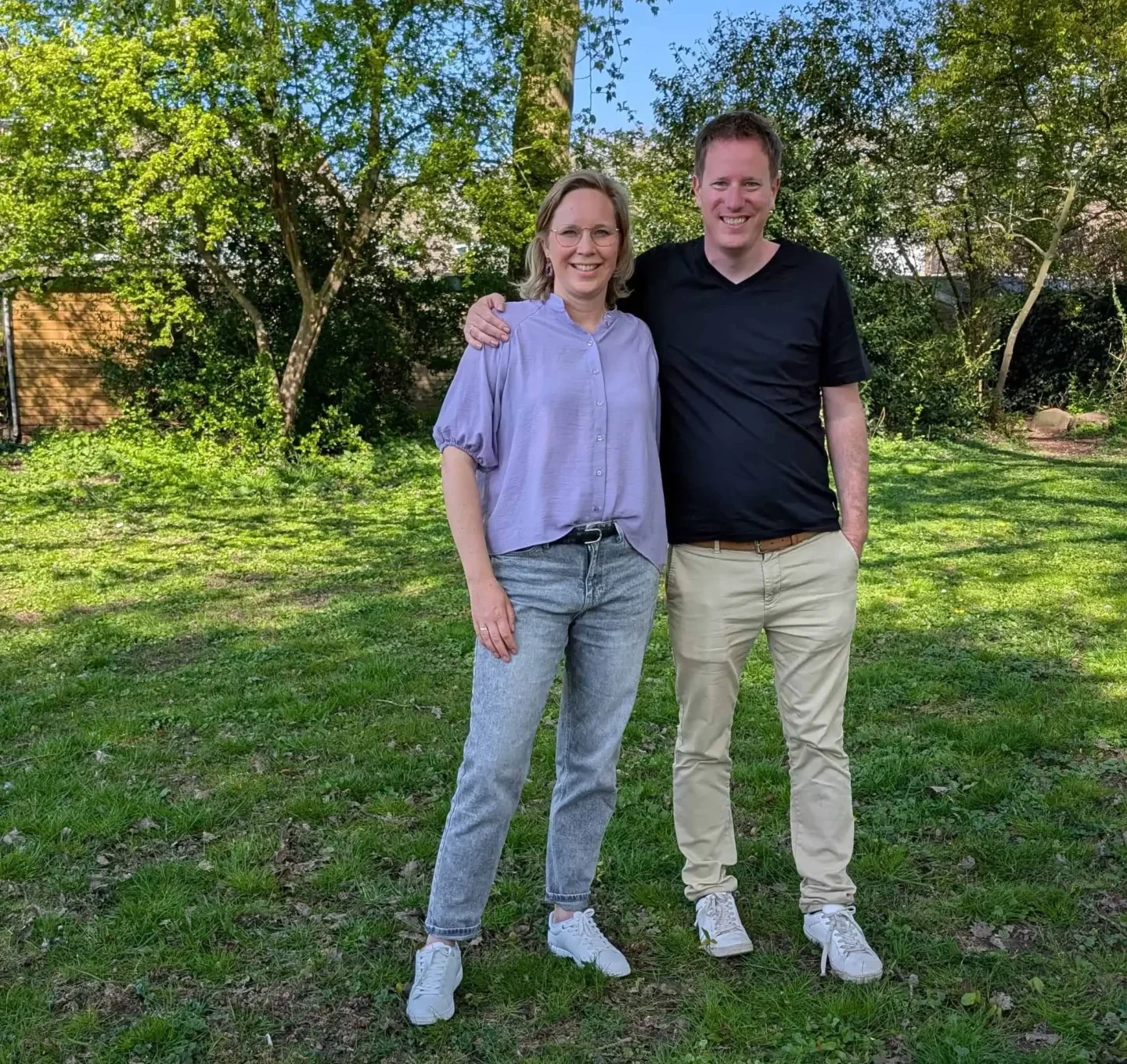 Timon en Jessica staan samen buiten in een groene omgeving op een zonnige dag.